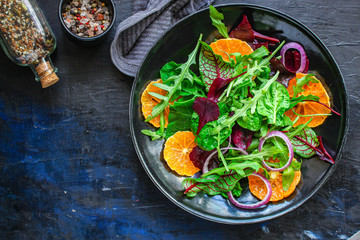 healthy salad tangerines citrus, lettuce, arugula and other herbs. Menu concept food background, keto or paleo diet. top view. copy space for text