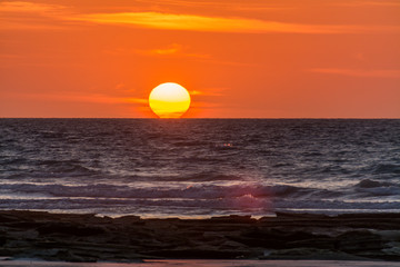 Sun kissing the ocean on a colorful sunset in Broome WA