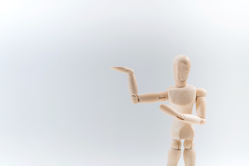 Wooden dummy proudly presents some invisible thing, isolated on white background, copy space for your object or text