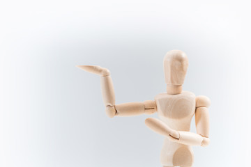 Wooden dummy proudly presents some invisible thing, isolated on white background, copy space for your object or text