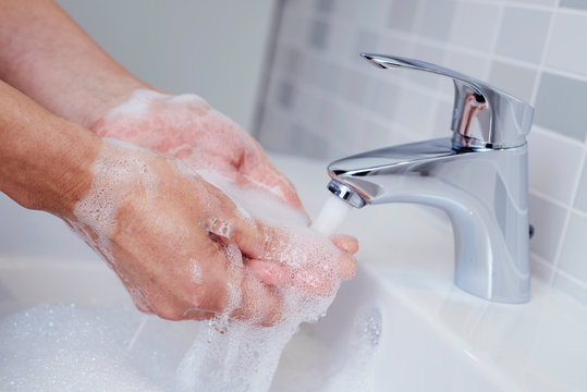 man washing his hands in a sink