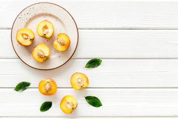 Healthy food. Ripe sliced peaches on plate on white wooden table top-down copy space