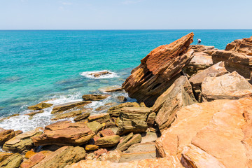 Fototapeta na wymiar Broome, WA / Australia - People fishing off the hazardous cliff rocks