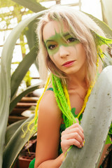 Dryad stands among the trees. Portrait of a beautiful girl with makeup on her face. Forest Nymph