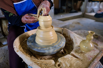 Closeup of Local woman demonstrates on making traditional clay jar called "Labu Sayong" or Essence Jar of Sayong in Kuala Kangsar, Perak, Malaysia.