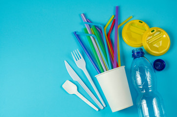 white single use plastic and plastic drink straws on a blue background say no to single use