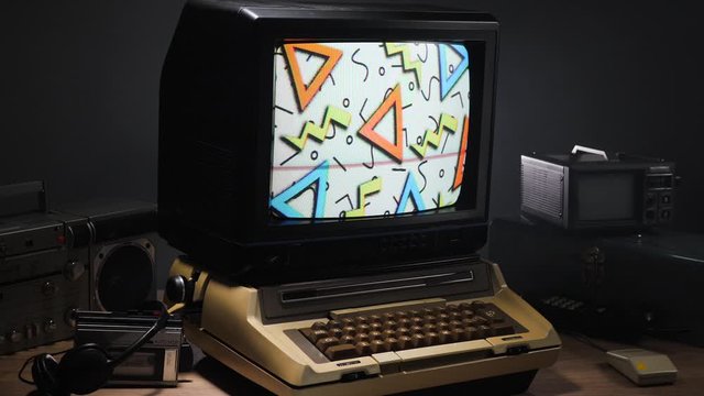 Old computer and monitor setup fro the 70s 80s 90s with Memphis design inspired background on it being animated.