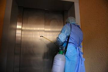 Paramedic wearing protective costume and mask disinfecting coronavirus with the sprayer