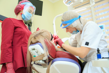 The dentist performs manipulations with the patient with an assistant