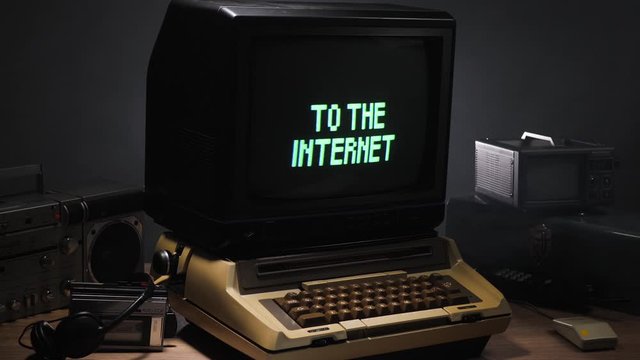 Vintage computer setup from the 70s 80s with a Connecting to the Internet message blinking on the monitor. Old tech concept.