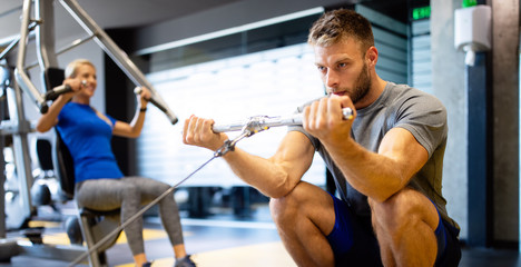 Naklejka premium Man with weight training equipment exercising in sport gym club