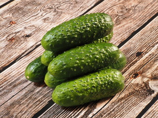 Fresh green cucumbers on wooden background.
