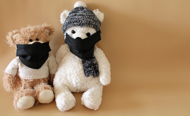 Soft toys bears in a black medical masks on a beige background. Schools and kindergartens are under quarantine. Home schooling. Copy space