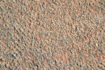 The texture of pink, old, weathered granite with small small patches.