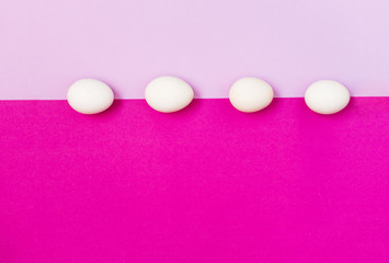 White easter egg on a lilac and rose background, flat lay, copy text
