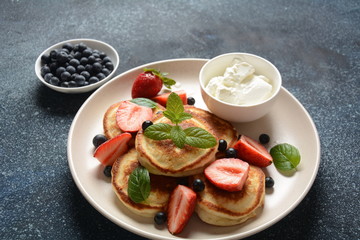 Sweet pancakes served with fresh blueberries , mint, strawberries,organic agave syrup. Healthy breakfast concept