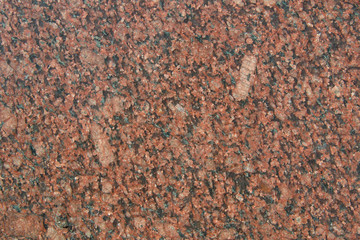 The texture of the red slice of granite with small black, pink and transparent blotches. Mica, spar...