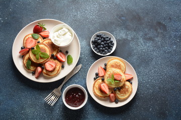 Sweet pancakes served with fresh blueberries , mint, strawberries,organic agave syrup. Healthy breakfast concept