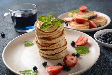 Sweet pancakes served with fresh blueberries , mint, strawberries,organic agave syrup. Healthy breakfast concept