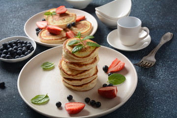 Sweet pancakes served with fresh blueberries , mint, strawberries,organic agave syrup. Healthy breakfast concept