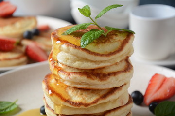 Sweet pancakes served with fresh blueberries , mint, strawberries,organic agave syrup. Healthy breakfast concept