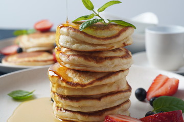 Sweet pancakes served with fresh blueberries , mint, strawberries,organic agave syrup. Healthy breakfast concept