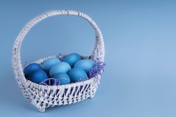 Easter eggs are blue and light blue in a beautiful basket. spring composition