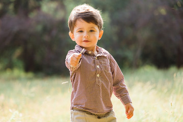 Cute little boy having fun in summer park. Happy child outdoors