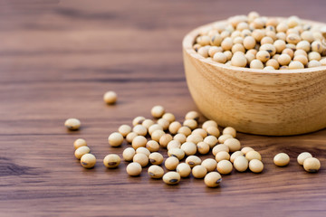 Soy beans in wooden bowl  isolated on wood table background.