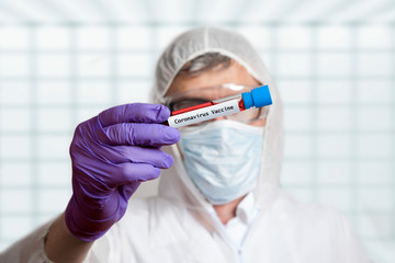 scientist holds coronavirus vaccine in test tube