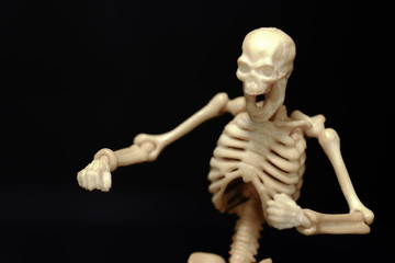 closeup view Isolated plastic toy skeleton on black background