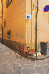 red bicycle parked in pisa