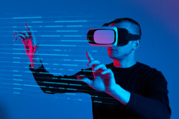 VR, AR, MR, XR-  Future technology. Neon. European man's in VR-glasses in neon on gradient background. Male portrait. Concept of human emotions, facial expression, modern gadgets and technologies