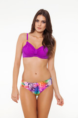 Obraz premium beautiful girl posing in stylish detailed colorful and purple swimsuit on white background.