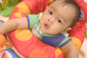 Obraz premium Portrait of a happy asian 4 months baby playing with toys,baby jumper