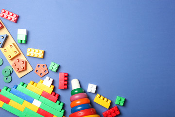 Set of different children's toys on a colored background top view. A place to insert text, minimalism. Baby background.