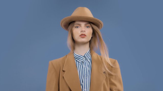 Fashion editorial portrait of blonde model with hair blowing in slow motion from 60 fps
