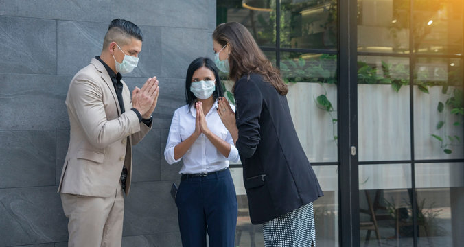 Group of employees with boss purt mask Standing Greetings, raising hands, hello, hands splice instead shake hands prevent infection, covid, 19 Section health treatment.Health concept.