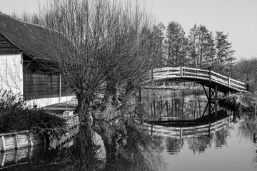  wooden bridge over the river giving access to the house in black and white