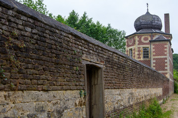 Fototapeta premium old fence wall of a castle with a small entrance gate