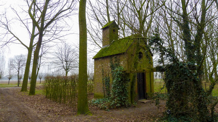 old chapel, surrounded by trees in the middle of the landscape