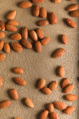 Almonds on a beige textured concrete background. Place for text. Aesthetic photography.