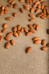 Almonds on a beige textured concrete background. Place for text. Aesthetic photography.