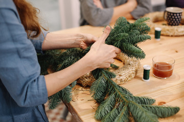 Base for Christmas wreath. Christmas decorations. Christmas wreath. Florist making Christmas wreath. View of female hands make a wreath.