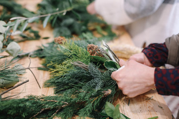 Base for Christmas wreath. Christmas decorations. Christmas wreath. Florist making Christmas wreath. View of female hands make a wreath.