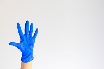 Hand in blue medical glove, five fingers, palm open hand. Medicine, hygiene, virus protection and COVID-19 coronavirus pandemic concept. Copy space. Place for your text.