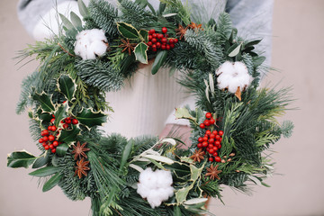 Fototapeta na wymiar Base for Christmas wreath. Christmas decorations. Christmas wreath. Florist making Christmas wreath. View of female hands holding a wreath.