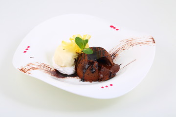 Chocolate flan with vanilla ice cream on a white plate