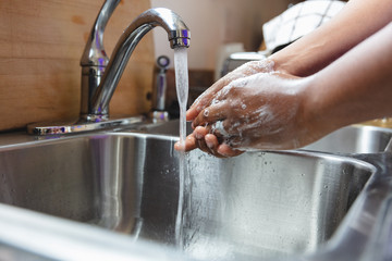 Black man washing hands in sink