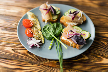 Fresh bread, fish and vegetables sandwiches. Food background, ingredients on the table. Healthy food, styling, cooking concept.